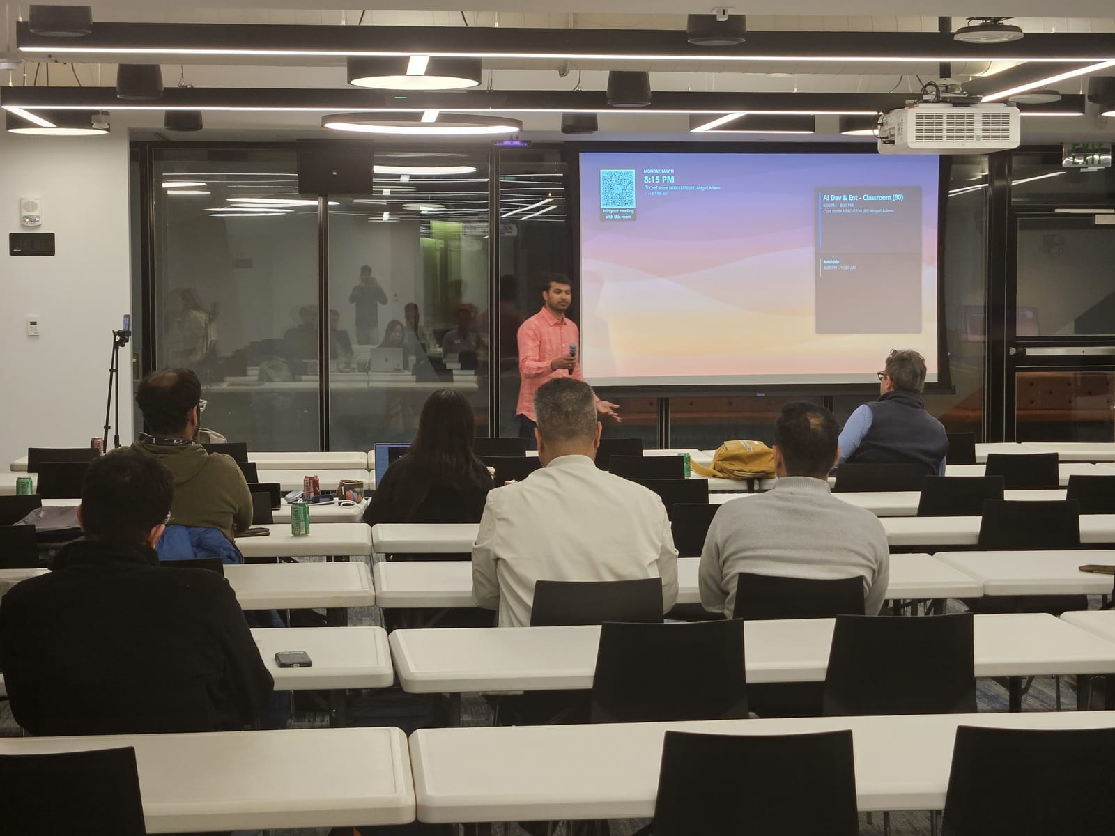 A speaker presenting to the seated audience